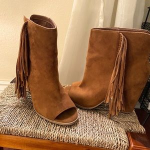 Brown suede ankle boots with open toe and fringe.